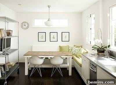 Modern kitchen with a white banquette contrasting against dark flooring, creating a visually appealing dining area.