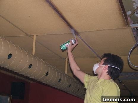 Spraying the ceiling grid with copper paint.