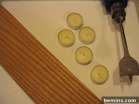 Five tea candles sit near a tool.