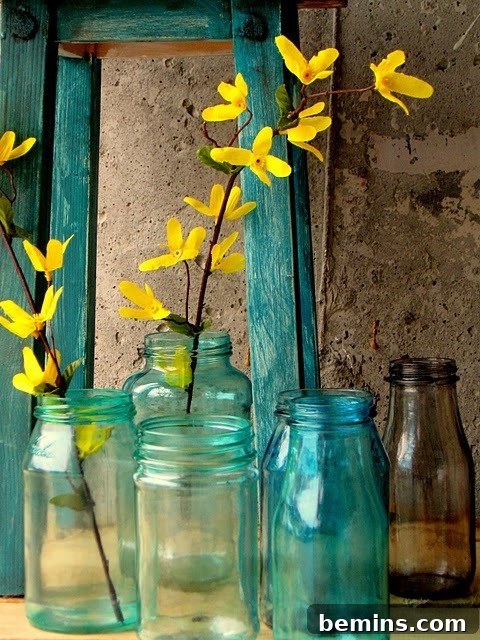 How to Tint Transparent Glassware at Home 2 Blue color glass bottles with yellow color flowers stem inside.