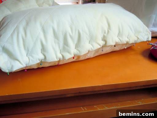 Turning Old Pillows into Dreamy Comfort: A DIY Transformation 12 A pillow fully pinned, ready for sewing, with colorful round-headed pins holding the fabric in place.