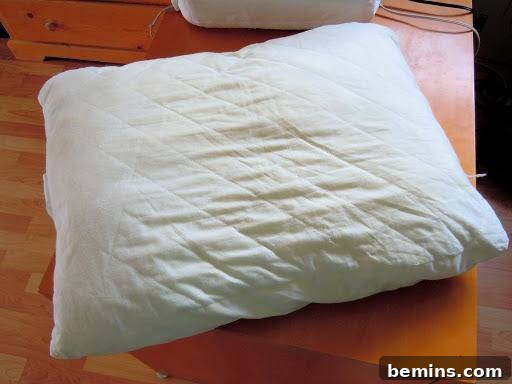 Turning Old Pillows into Dreamy Comfort: A DIY Transformation 5 A single bed pillow lying on a desk, ready to be transformed into decorative throw pillows.