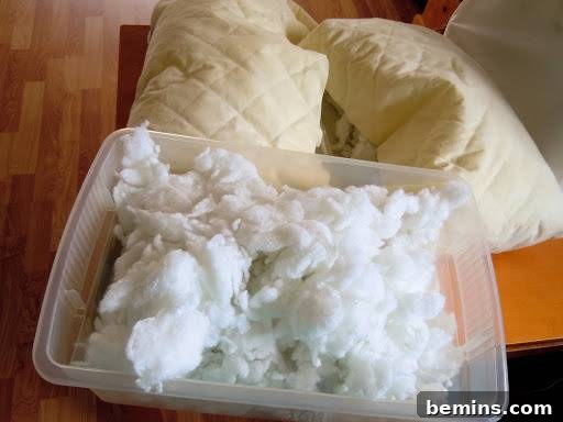 Turning Old Pillows into Dreamy Comfort: A DIY Transformation 7 Image showing excess pillow stuffing being removed and stored for later use in other DIY projects.