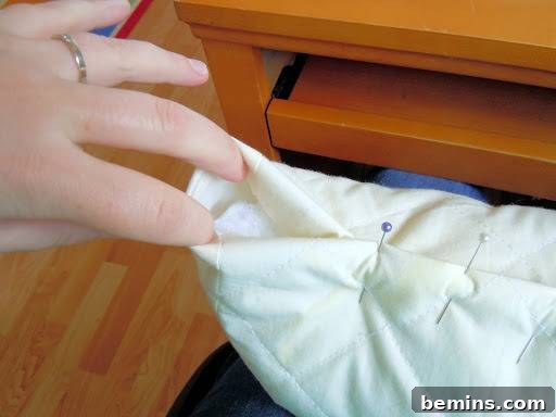 Turning Old Pillows into Dreamy Comfort: A DIY Transformation 10 Demonstration of how to handle and pin extra fabric at the ends of the pillow.