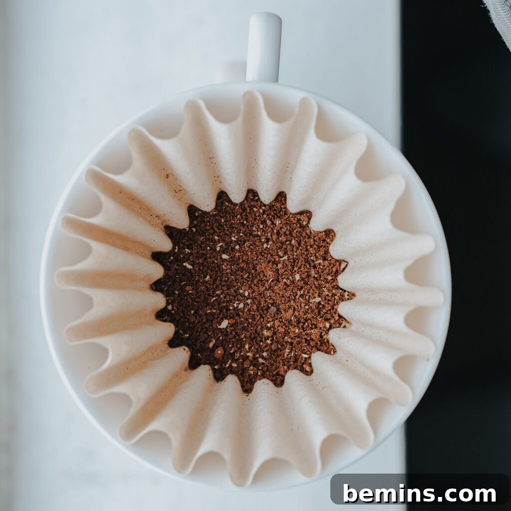Creative Ways to Repurpose Your Coffee Grounds: Get Your Free Guide 2 Coffee grounds in a coffee maker, showcasing their potential for reuse.