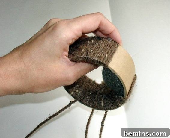 Wrapping the yarn around the painter's tape roll to create the bracelet
