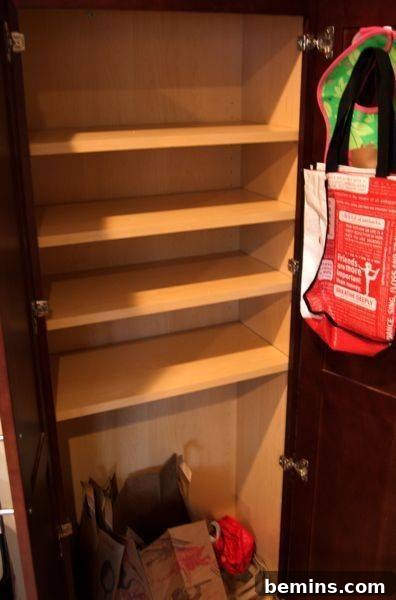 An empty four-tier shelf with a pile of miscellaneous items at the bottom.