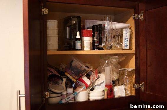 A precarious stack of glassware and fragile items in an upper pantry shelf.