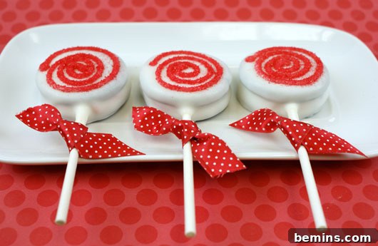 Red and white desserts on sticks with red bows.