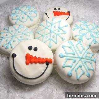 Cookies decorated with blue icing and snowman faces.