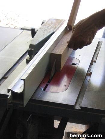 A person running a 2x4 vertically through a circular saw. Shows the process of cutting the groove with the table saw.