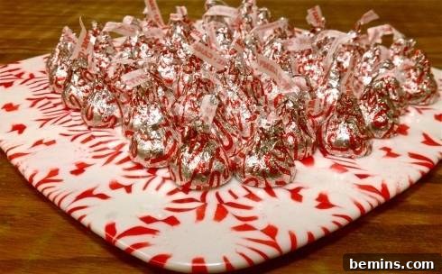 A perfectly formed candy bowl made from melted hard candy, holding chocolate kisses, showcasing a smooth, clear finish.