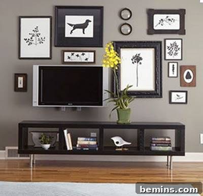 Several black and white paintings hanging over a TV, demonstrating how to balance technology with art in a living space.