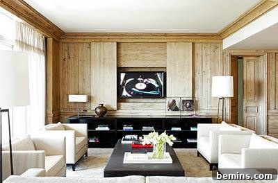 A modern living room features a TV integrated into a designer unit, complemented by stylish sofa chairs and a central table.