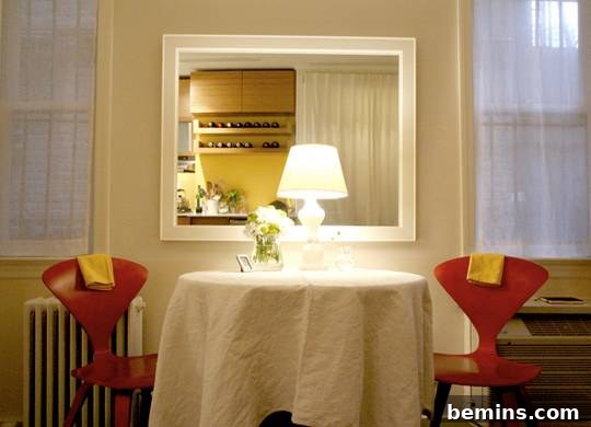 Dining table with a lamp and a mirror, maximizing light and ambiance in a small kitchen