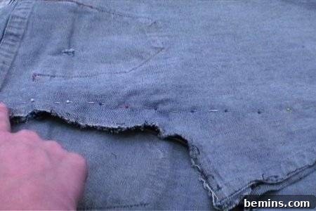 From Denim to Dream Skirt: A DIY Transformation 17 Man showing sewing stitches of fabric with hand, indicating where to pin the back seam.