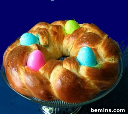 Round shaped baking bread with colorful decorative eggs on it.