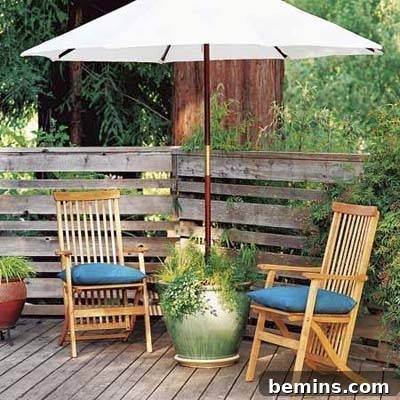 8 Ingenious DIY Garden Ideas for Compact Spaces 9 Clever container garden serving as a stable base for a large patio umbrella, adorned with lush foliage