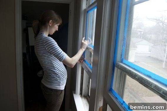 Taping the windows - Careful preparation including taping before painting the nursery trim.