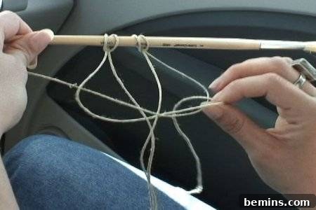 Hands holding a paintbrush with hanging hemp twine