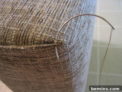 Basket with upholstered fabric using curved needles