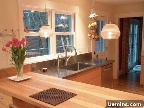 A kitchen with a wooden island table and contrasting countertop materials, showcasing a modern design approach.