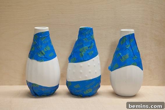 DIY Colorful Paint-Dipped Flower Vases: A Step-by-Step Guide 7 Pressing down the edges of the painter's tape on the vase