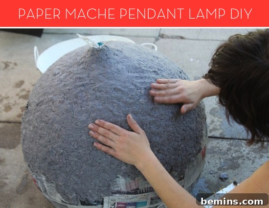 Close-up of paper mache layers being applied for a DIY lamp