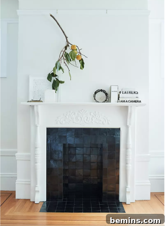Inspired Fireplace Tile Designs for a Warm Home 17 black tiled fireplace with white ornate surround.