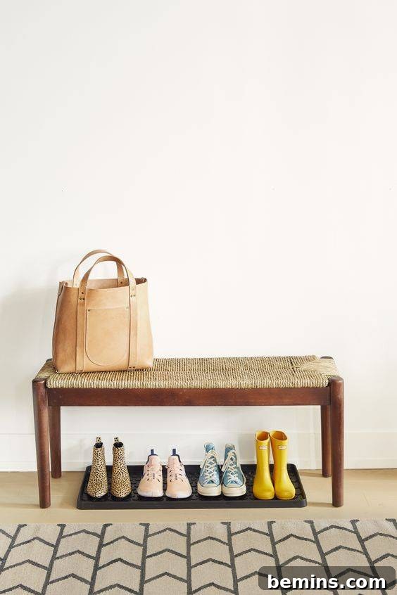 Shoe trays under a bench to keep the floor clean.