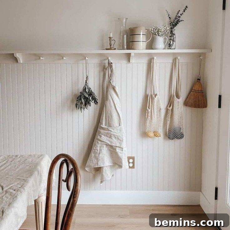 White shelf over beadboard wainscoting with purse and bags hanging