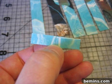 Crafting Connections: A Guide to Paper Chain Creations 8 Hand holding a blue colored folded paper strip, showing the folding details.