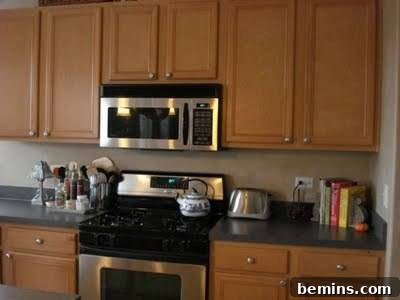 5 Quick and Budget-Friendly Cabinet Refresh Ideas 3 A kitchen with ash-colored wood cabinets before glazing.
