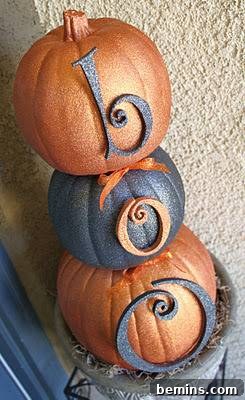 Three pumpkins stacked on top of each other painted orange and black for fall home decor
