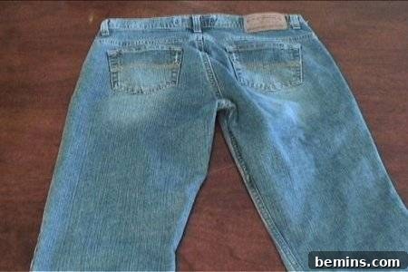 How to Sew Your Own Overalls 13 A blue colour jeans is spreading in the brown colour floor.