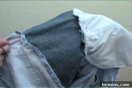 How to Sew Your Own Overalls 21 A man holding a piece of cloth which is made of denim.