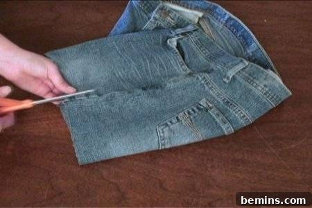 Woman is cutting pant cloth with scissor.