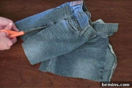 How to Sew Your Own Overalls 28 ''A person cuts a pant using sissors, to make overalls
