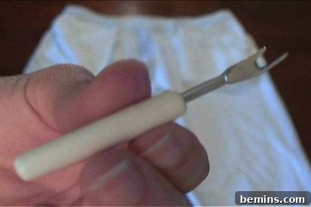 How to Sew Your Own Overalls 4 An up close seam ripper sits on a pile of fabric