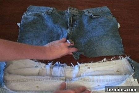 How to Sew Your Own Overalls 31 Hands holding the crotch of a cut-off pair of denim bottoms above another paler denim bottom with a raw edge.