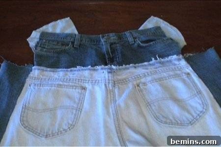 How to Sew Your Own Overalls 34 A light pair of jeans lays on top of a cut up pair of jeans.