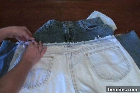 How to Sew Your Own Overalls 35 Hands holding overlapping denim bottoms, the top pair a lighter denim with a raw edge.