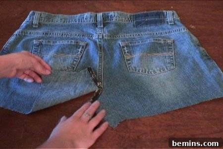Woman opening jean pant cut piece with hand.
