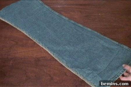 How to Sew Your Own Overalls 45 Woman holding jean pant fabric with hand.