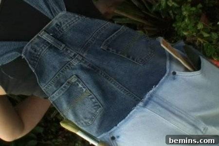 A person wearing overall made of denim with big pockets.