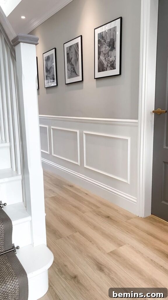 Charming Wainscoting: 21 Ways to Elevate Your Home 2 White traditional wainscoting in entryway with staircase and photographs