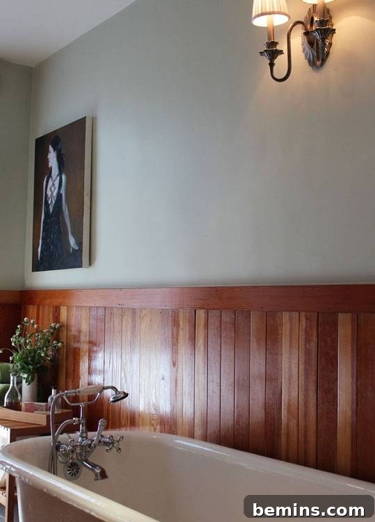 Charming Wainscoting: 21 Ways to Elevate Your Home 18 Reclaimed wood wainscoting in bathroom with cream above wood, with picture frame.