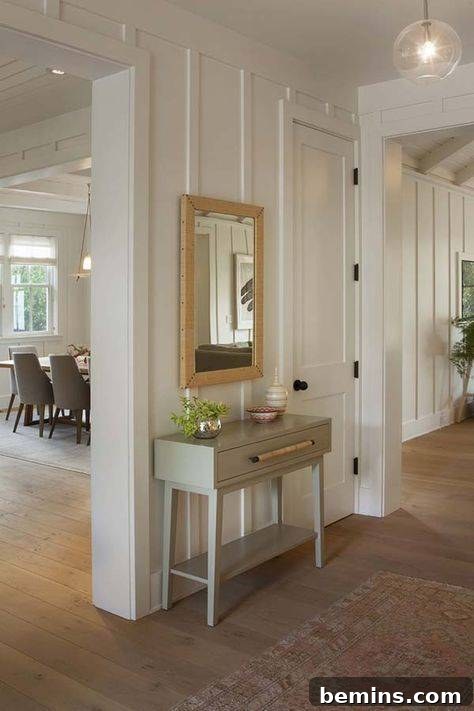 Charming Wainscoting: 21 Ways to Elevate Your Home 21 Vertical cream colored wainscoting panels with beige framed mirror and grey table.