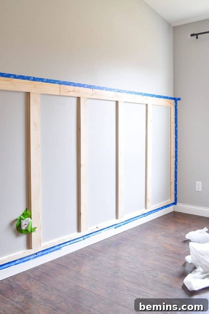 Charming Wainscoting: 21 Ways to Elevate Your Home 9 DIY board and batten wainscoting, white, with blue tape