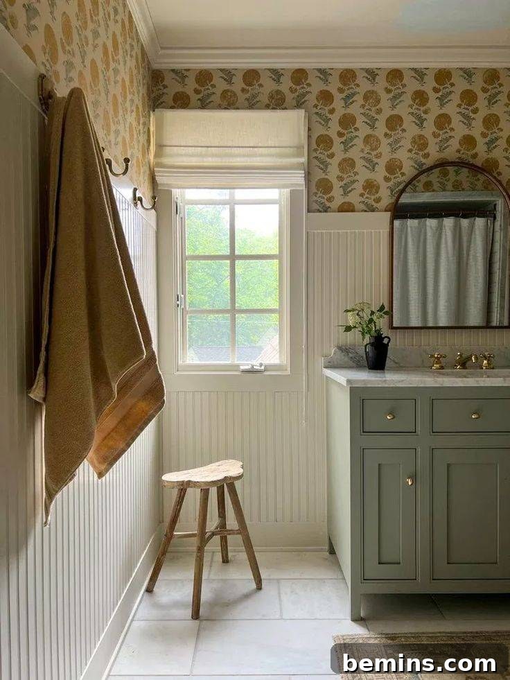 Cream colored bathroom with sage green sink and vertical wainscoting 